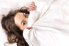 woman hiding under covers