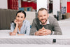 couple resting on showroom floor mattress