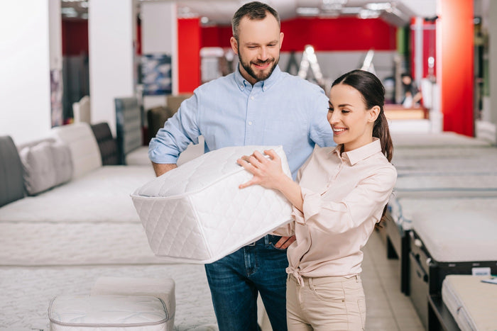couple testing mattress firmness
