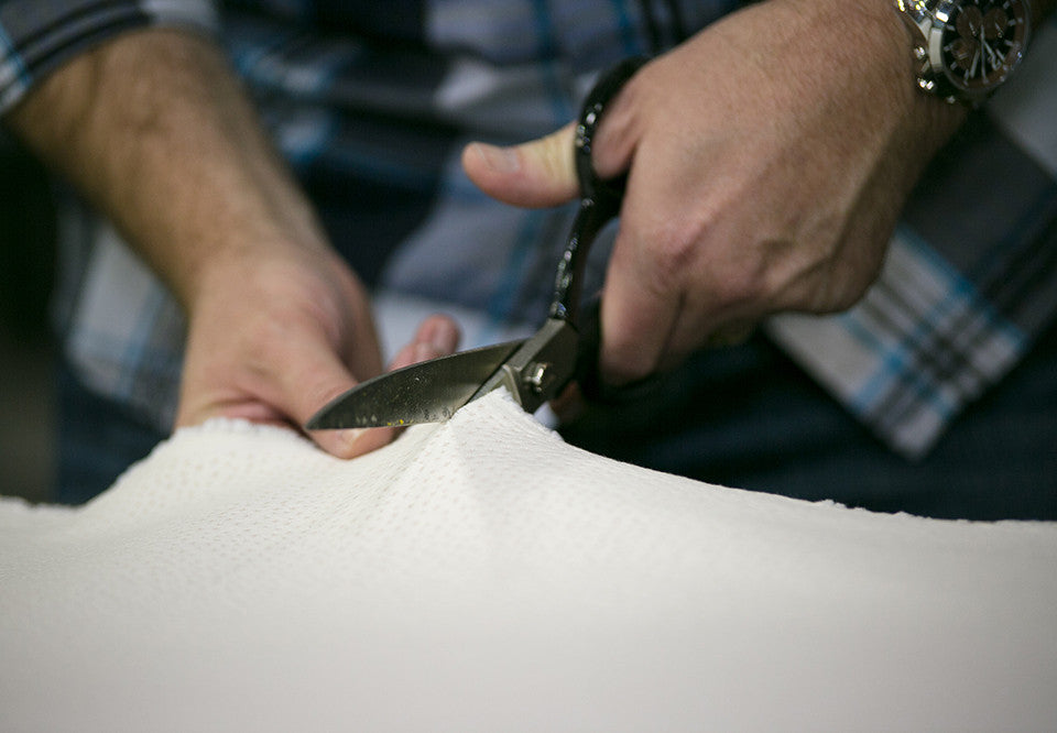 A Latex for Less craftsman finishing a mattress in the factory